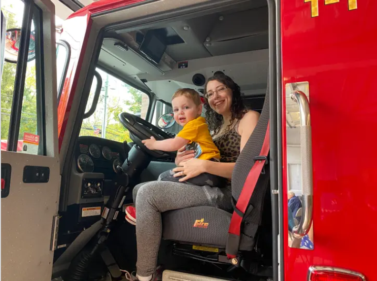 This youngster - a firefighter in the making? - receives an assist from his mom as they get behind the wheel of a fire truck at the annual Community Day event at the Golden's Bridge Fire Department. (GBFD)