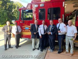 Officials of the Golden’s Bridge Fire District and Golden’s Bridge Fire Department welcomed New York State Sen. Peter Harckham when he visited the firehouse to announce a $100,000 state grant for new radio communications equipment purchased by the District, a purchase necessitated because new radio frequencies have been implemented by the dispatch center of the Westchester County Department of Emergency Services. Displaying some of the new radios in this photo are (l.-r.) Firefighter Elias Scharfenberg, Fire Chief Albert Melillo, Chairman of the Board of Fire Commissioners Edward Brancati, Fire Commissioner and ex-Chief Robert Melillo, Sen. Peter Harckham, Captain Raymond Baker Jr., and Fire Commissioner Robert Kelly. 
